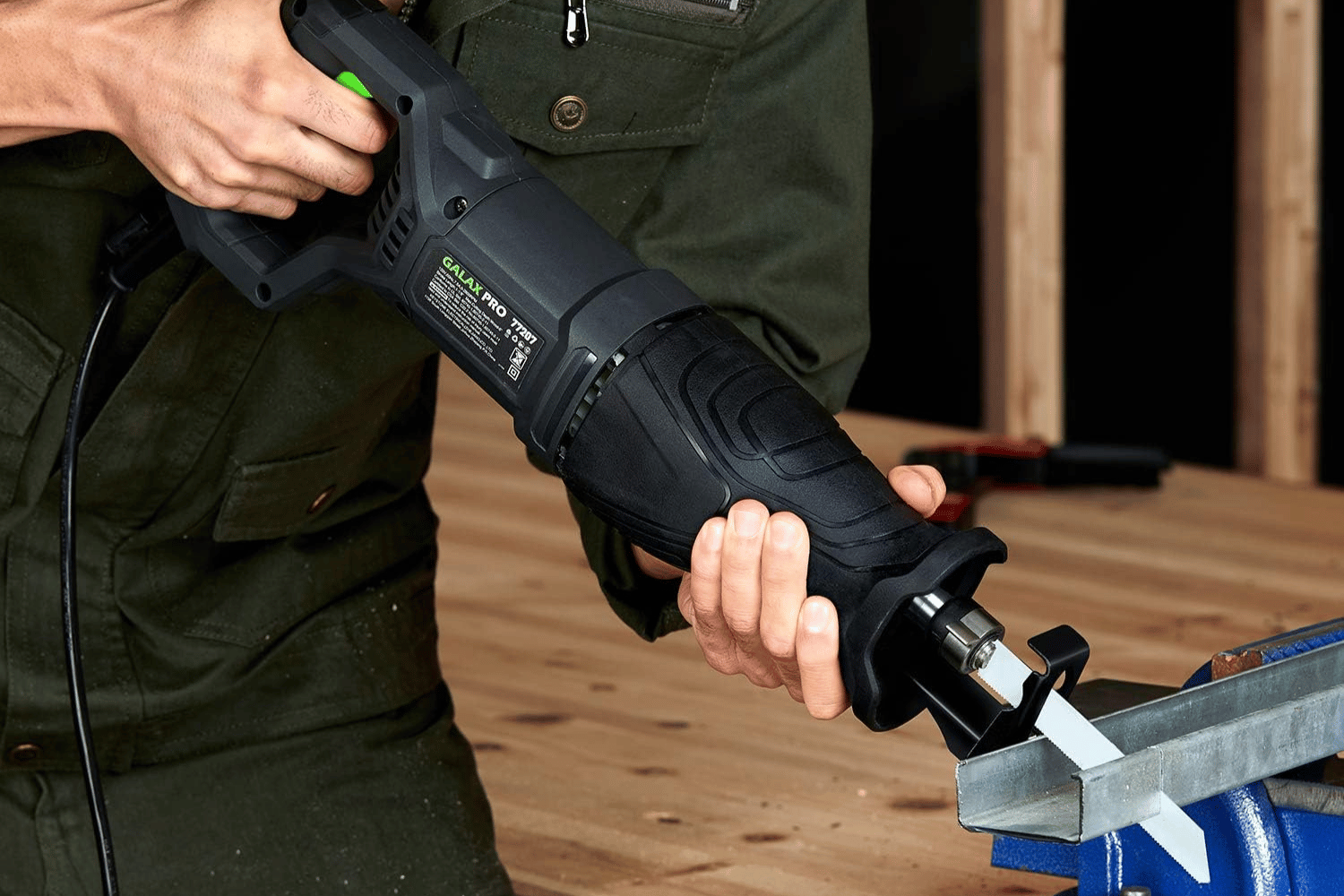 A person using a corded reciprocating saw to cut metal