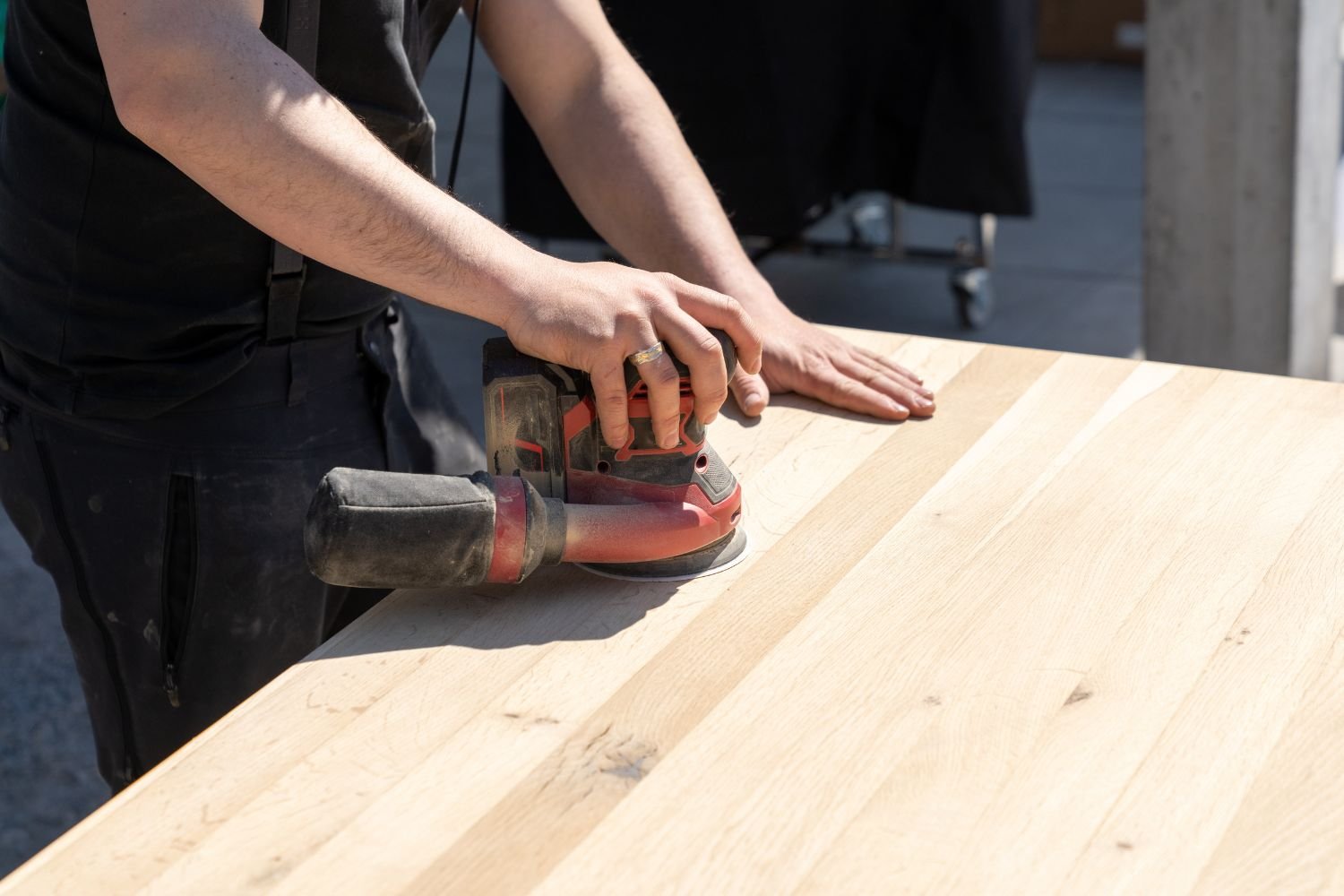 Random Orbit Sander smoothing a table top with a circular sanding pad