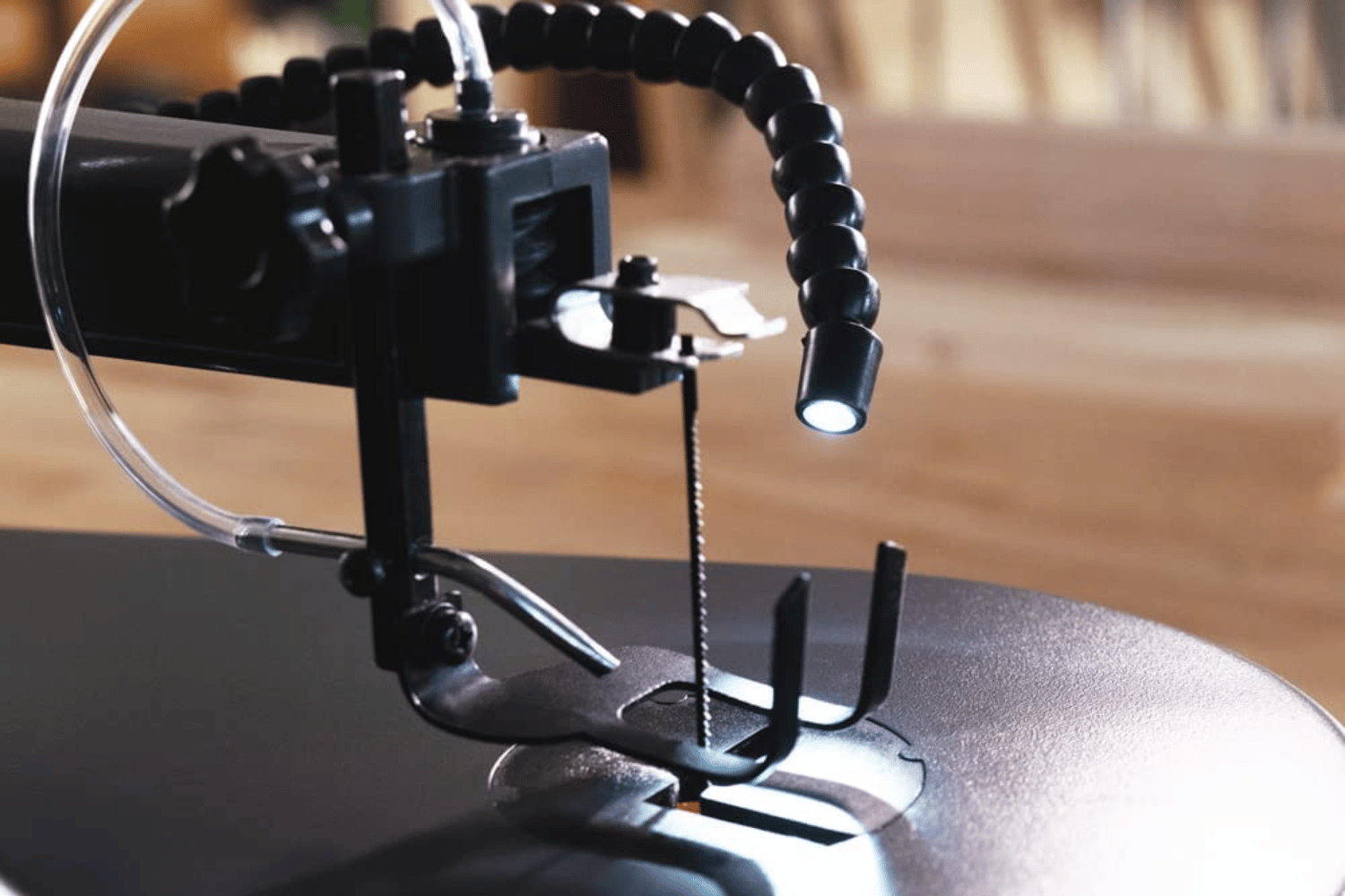 Scroll saw with a dust blower and a foot pedal for variable speed