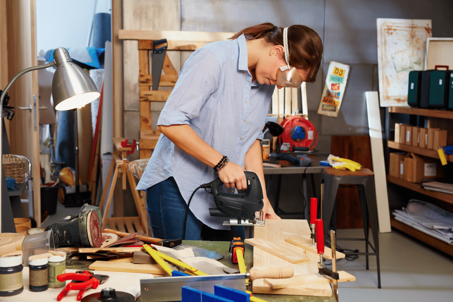 A person using a cordless jigsaw with proper handling and protective gear