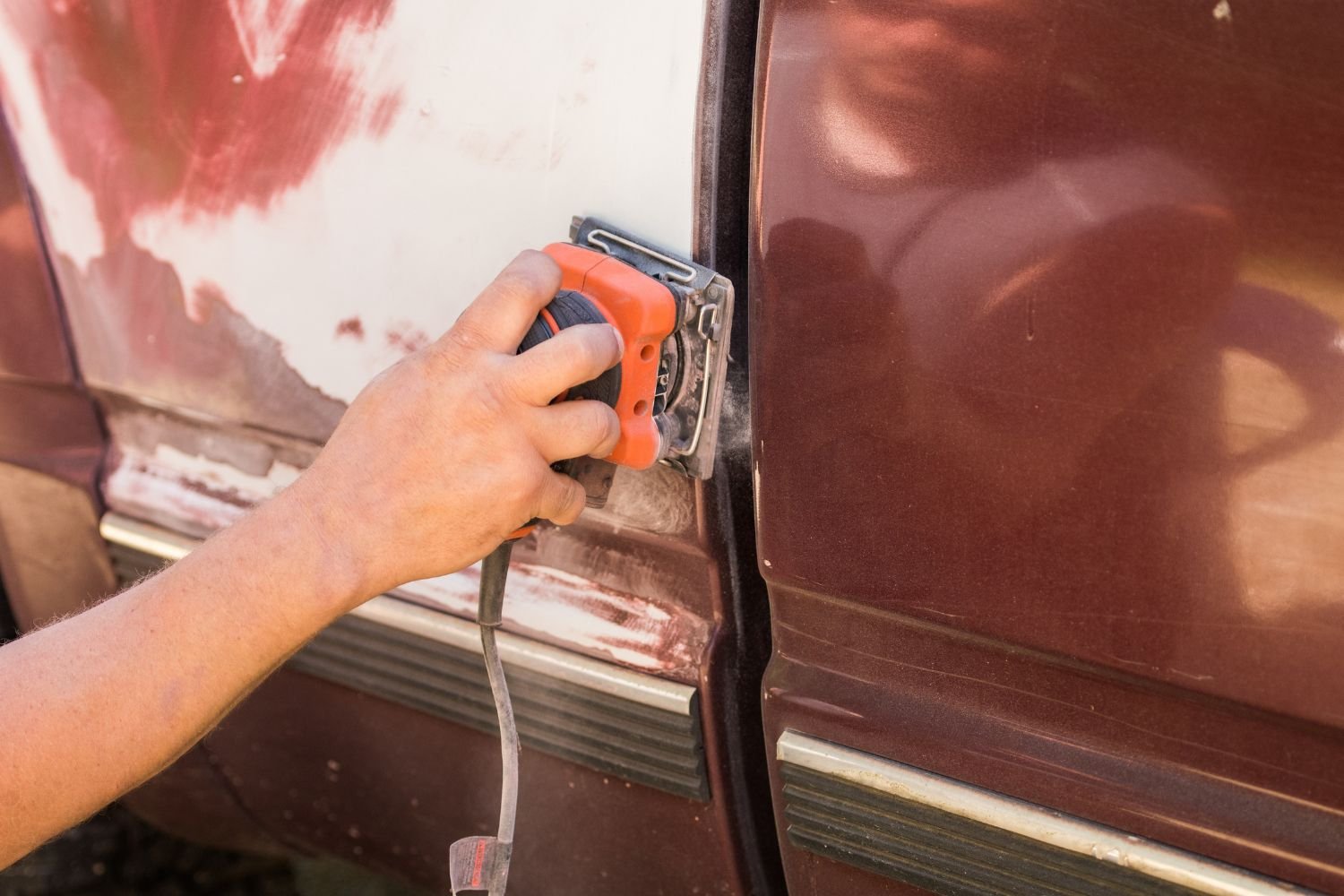 Using a Palm Sander on a vehicle panel before repainting