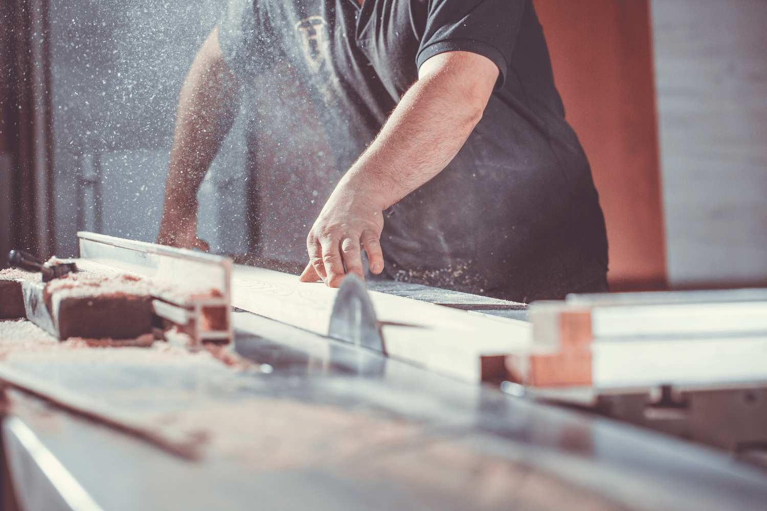A person using a table saw to edge joint one edge of a board